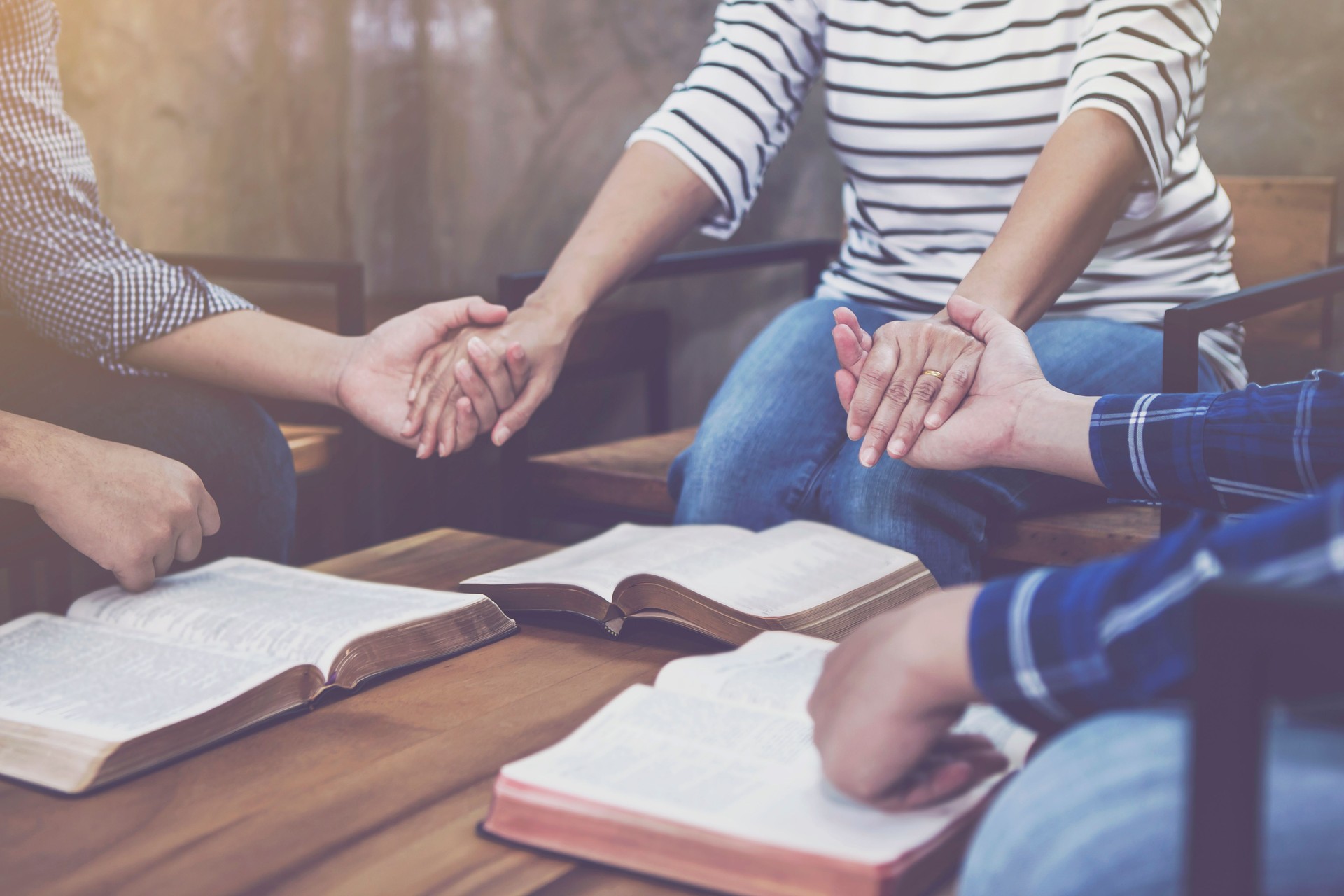 A Christian group holding hands and pray together